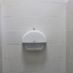 Белый держатель для туалетной бумаги на кафельной стене